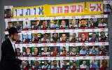 People walking next to pictures of hostages held by terrorists in Gaza, in Jerusalem, July 2, 2025 (Yonatan Sindel/Flash90)