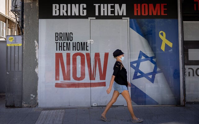 People walk past a sign calling for the release of hostages, in Tel Aviv. July 7, 2025 (Miriam Alster/FLASH90) People walk past a sign calling for the release of hostages, in Tel Aviv. July 7, 2025 (Miriam Alster/FLASH90)