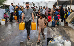 Palestinians collect drinking water in Khan Younis, in the southern Gaza Strip, July 13, 2025. (Abed Rahim Khatib/Flash90)
