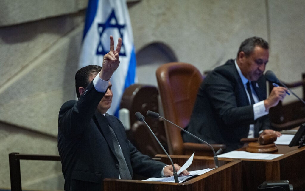 Hadash-Ta'al chair Ayman Odeh flashes a victory sign while speaking in the Knesset, ahead of a vote on a motion to expel him, July 14, 2025. (Yonatan Sindel/Flash90)