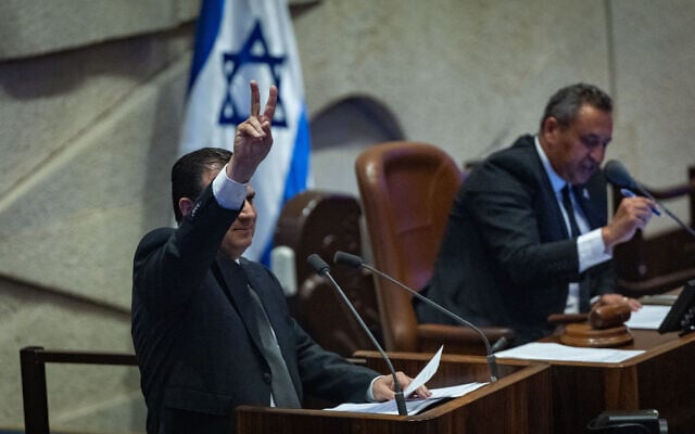 Hadash-Ta'al chair Ayman Odeh flashes a victory sign while speaking in the Knesset, ahead of a vote on a motion to expel him, July 14, 2025. (Yonatan Sindel/Flash90)