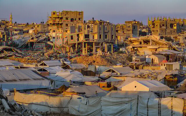 Palestinians at sunset amid ongoing Israeli attacks, in Al-Bureij refugee camp in the central Gaza Strip, July 22, 2025. (Ali Hassan/Flash90)