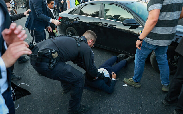Ultra-Orthodox Jewish men block a road and clash with police outside Bnei Brak, during a protest on July 23, 2025. (David Cohen/Flash90)