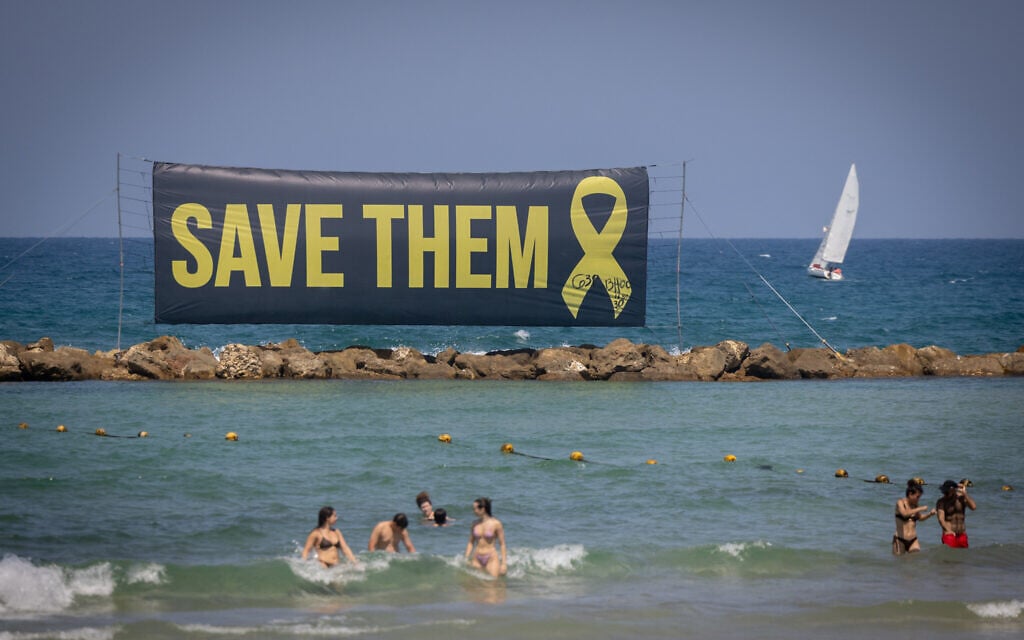 SIgns calling for the release os the Israeli hostages in Gaza, at the beach in Tel Aviv. July 24, 2025. (Miriam Alster/Flash90)