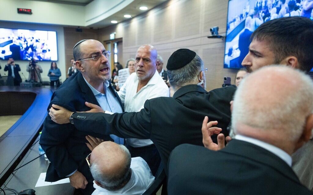 MK Nissim Vaturi is held back during a scuffle with an aide to MK Naama Lazimi during a Knesset House committee meeting in Jerusalem on July 29, 2025. (Chaim Goldberg/Flash90)