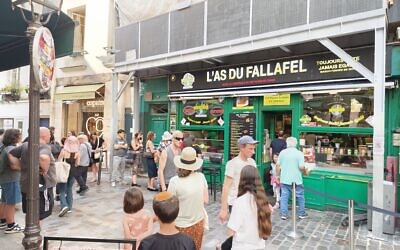 Customers wait outside of L’As du Fallafel in the historically Jewish Le Marais neighborhood of Paris, July 11, 2025 (Zev Stub/Times of Israel)