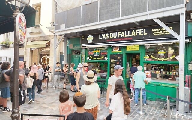 Customers wait outside of L’As du Fallafel in the historically Jewish Le Marais neighborhood of Paris, July 11, 2025 (Zev Stub/Times of Israel)