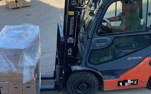 This handout picture, released by Israel's health ministry on July 21, 2025, shows a worker driving in a forklift that crates set to be filled with medical supplies and sent to a hospital in Sweida, Syria, amid sectarian violence there.