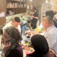 The cholent served on Thursday nights at Hadar Geula in Jerusalem is scooped from giant pots behind a packed counter. (Philissa Cramer/ JTA)