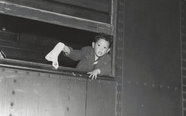 Tommy Yoneda on the train to Manzanar, waving goodbye. (Courtesy of Karl G. Yoneda Papers, UCLA Library Special Collections)