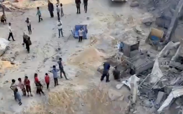 People survey the damage from a reported Israeli airstrike on Khan Younis in the southern Gaza Strip, July 28, 2025. (Screen capture: X/Palestinian Information Center)