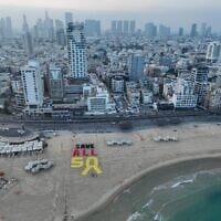 A display created on a Tel Aviv beach calls for the release of all remaining Gaza hostages amid negotiations for a 60-day ceasefire, on July 11, 2025. (Avishai Reisner/Pro-Democracy Protest Movement)