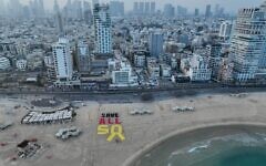 A display created on a Tel Aviv beach calls for the release of all remaining Gaza hostages amid negotiations for a 60-day ceasefire, on July 11, 2025. (Avishai Reisner/Pro-Democracy Protest Movement)
