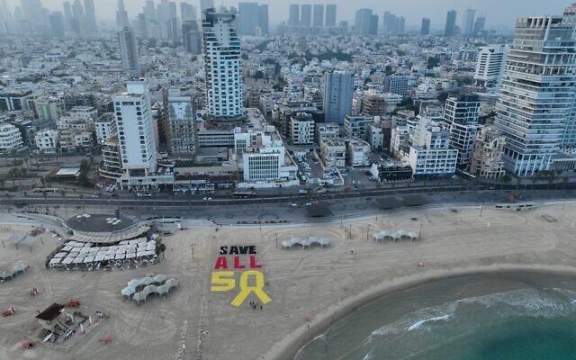 A display created on a Tel Aviv beach calls for the release of all remaining Gaza hostages amid negotiations for a 60-day ceasefire, on July 11, 2025. (Avishai Reisner/Pro-Democracy Protest Movement)