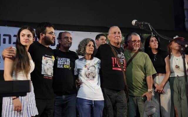 Friends and family mark hostage Nimrod Cohen's 21st birthday in Tel Aviv’s Hostages Square, including (L-R) Nimrod’s twin sister, Romi; his brother Yotam; father Yehuda; mother Viki; former hostage Gadi Mozes; Dani Elgarat, brother of murdered hostage Itzik Elgarat; Einav Zangauker, mother of hostage Matan Zangauker; and former hostage Ilana Gritzewsky, July 17, 2025. (Alon Gilboa)