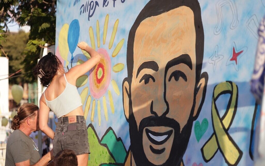 Supporters write messages of hope on Wall of Hope created by graffiti artist Tania Dodescu, featuring hostage Nimrod Cohen on his 21st birthday, in Tel Aviv, July 17, 2025. (Credit Alon Gilboa)