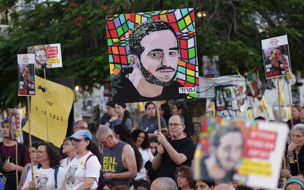 Artist Shoshke Engelmayer holds his illustration of hostage Nimrod Cohen at Tel Aviv's Hostages Square on Nimrod's 21st birthday, July 17, 2025. (Credit Alon Gilboa)