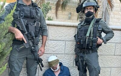 Border Police officers pose with Abed al-Karim Snober, a Palestinian terrorist accused of carrying out a botched bus bombing attack in February, following his arrest on July 22, 2025. (Israel Police)