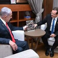 President Isaac Herzog (right) meets with Prime Minister Benjamin Netanyahu in Jerusalem, July 6, 2025. On the table is  a picture of the hostages held in Gaza. (Haim Zach/GPO)