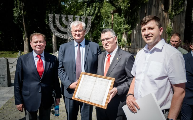 Ukraine's ambassador to Israel Yevgen Korniychuk (left), Foreign Minister Andrii Sybiha (2nd from left) presents Foreign Minister Gideon Sa'ar (second from right) with a copy of 19th century documents and birth certificates from his Ukrainian ancestors, July 23, 2025. (Embassy of Ukraine in Israel)
