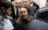 Jailed Fatah leader Marwan Barghouti (C) is accompanied by Israeli prison guards after a hearing at Jerusalem Magistrate's Court, January 25, 2012. (REUTERS/Ammar Awad)