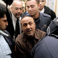 Jailed terror convict and Fatah leader Marwan Barghouti (C) is accompanied by Israeli prison guards after a hearing at Jerusalem Magistrate's Court, January 25, 2012. (REUTERS/Ammar Awad)