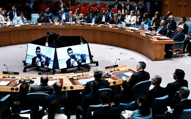 Ilay David is displayed on screen as he shows a picture of his brother of Evyatar David, who is held hostage by Hamas in Gaza, during a Security Council meeting at UN headquarters in New York City, August 5, 2025. At right, in front row with back to camera, is Israeli Foreign Minister Gideon Sa'ar. (REUTERS/Eduardo Munoz)
