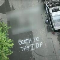 A screenshot of aerial footage from KMOV 4 News shows graffiti reading "Death to the IDF" and a burnt car on a street in Clayton, Missouri, August 6, 2025. (YouTube screenshot)