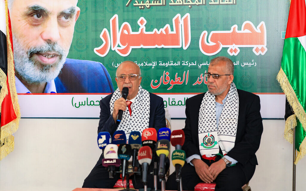 Yemen's Houthi-led government's Prime Minister Ahmed al-Rahawi (L) delivers a speech during his visit  to Hamas offices in Sanaa, to offer his condolences over the killing of Yahya Sinwar on October 20, 2024. (Photo by Mohammed HUWAIS / AFP)