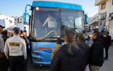 Illustrative: Palestinian security guards stand next to a bus taking patients from al-Shifa hospital in Gaza City for treatment through the Rafah crossing on February 1, 2025. (Bashar Taleb/AFP)