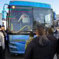 Illustrative: Palestinian security guards stand next to a bus taking patients from al-Shifa hospital in Gaza City for treatment through the Rafah crossing on February 1, 2025. (Bashar Taleb/AFP)