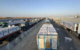 Trucks loaded with humanitarian aid await permission on the Egyptian side of the Rafah crossing with the Gaza Strip, August 3, 2025. (AFP)