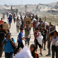 Illustrative: Palestinians leave a food distribution point run by the US and Israeli-backed Gaza Humanitarian Foundation with bags and boxes, near the Netzarim corridor in the central Gaza Strip, on August 3, 2025. (Eyad BABA / AFP)