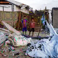 Children inspect the scene in the aftermath of overnight Israeli bombardment on a camp sheltering displaced people in the Mawasi area of Khan Younis in the southern Gaza Strip on August 5, 2025. (AFP)