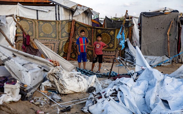 Children inspect the scene in the aftermath of overnight Israeli bombardment on a camp sheltering displaced people in the Mawasi area of Khan Younis in the southern Gaza Strip on August 5, 2025. (AFP) Children inspect the scene in the aftermath of overnight Israeli bombardment on a camp sheltering displaced people in the Mawasi area of Khan Younis in the southern Gaza Strip on August 5, 2025. (AFP)