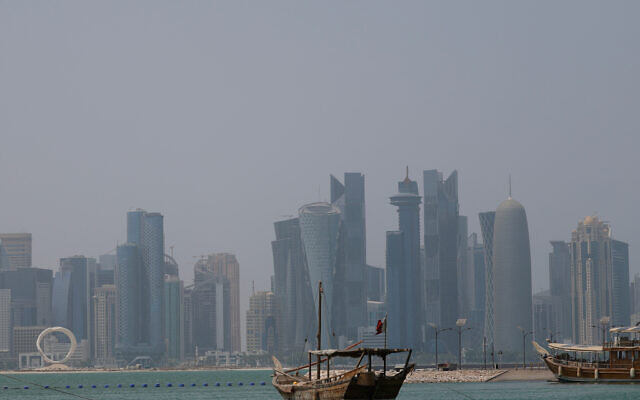A picture shows a moored dhow with the Doha skyline in the background on a hot and humid summer day on August 6, 2025. (Karim JAAFAR / AFP)