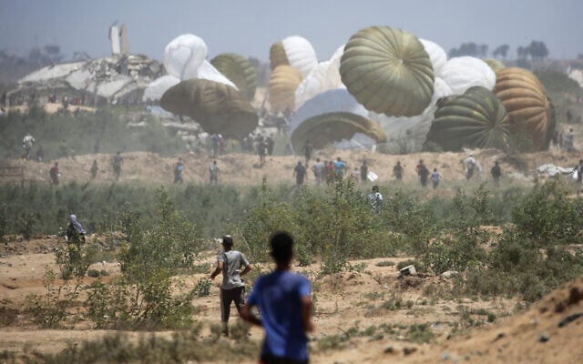 Palestinians rush to the site where parachuted aid packages are landing in the central Gaza Strip during an airdrop on August 6, 2025. (Eyad BABA / AFP) Palestinians rush to the site where parachuted aid packages are landing in the central Gaza Strip during an airdrop on August 6, 2025. (Eyad BABA / AFP)
