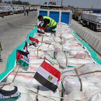 Volunteers arrange parcels as trucks loaded with humanitarian aid await permission on the Egyptian side of the Rafah crossing with the Gaza Strip, to enter the besieged Palestinians territory on August 6, 2025. (AFP)