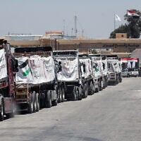Trucks loaded with humanitarian aid await permission on the Egyptian side of the Rafah crossing with the Gaza Strip, to enter the Palestinian territory on August 6, 2025. (AFP)