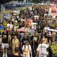 Relatives of Israeli hostages and demonstrators raise pictures and placards during an anti-government protest outside Defense Ministry headquarters in Tel Aviv on August 6, 2025. (JACK GUEZ / AFP)