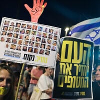 Demonstrators raise placards during an anti-government protest calling for the release hostages from the Gaza Strip, outside the IDF headquarters in Tel Aviv on August 6, 2025. (JACK GUEZ / AFP)