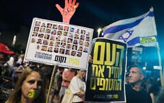 Demonstrators raise placards during an anti-government protest calling for the release hostages from the Gaza Strip, outside the IDF headquarters in Tel Aviv on August 6, 2025. (JACK GUEZ / AFP)