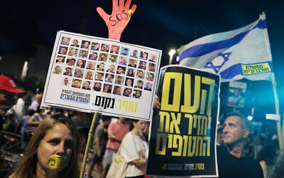 Demonstrators raise placards during an anti-government protest calling for the release hostages from the Gaza Strip, outside the IDF headquarters in Tel Aviv on August 6, 2025. (JACK GUEZ / AFP)