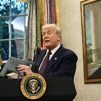 US President Donald Trump holds a model of a new version the B-2 stealth bomber as he speaks in the Oval Office of the White House in Washington, DC, on August 6, 2025. (Brendan SMIALOWSKI / AFP)