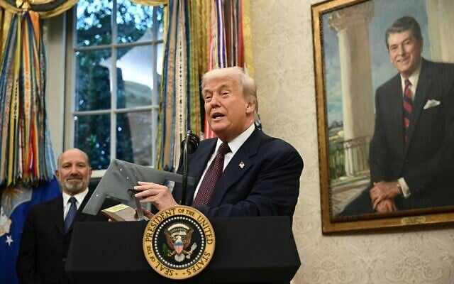 US President Donald Trump holds a model of a new version the B-2 stealth bomber as he speaks in the Oval Office of the White House in Washington, DC, on August 6, 2025. (Brendan SMIALOWSKI / AFP)