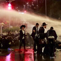 Police use a water canon to disperse ultra-Orthodox demonstrators as they protest military enlistment orders and the arrest of yeshiva students who avoided the orders, during a rally in Jerusalem on August 7, 2025. (Menahem KAHANA / AFP)