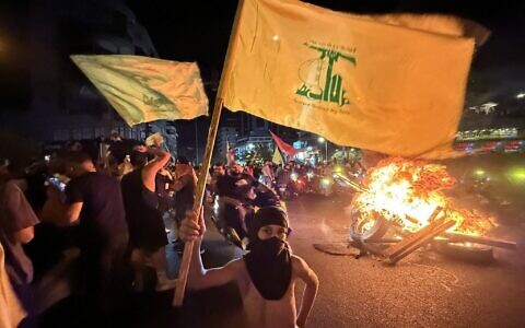 Supporters of Lebanon's Hezbollah terror group block the streets with burning tires as they rally in cars and motorbikes to protest the government's endorsement of a plan to disarm it, in Beirut's southern suburbs, early on August 8, 2025. (Ibrahim AMRO / AFP)
