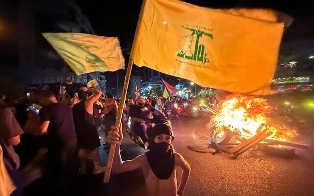 Supporters of Lebanon's Hezbollah terror group block the streets with burning tires as they rally in cars and motorbikes to protest the government's endorsement of a plan to disarm it, in Beirut's southern suburbs, early on August 8, 2025. (Ibrahim AMRO / AFP)