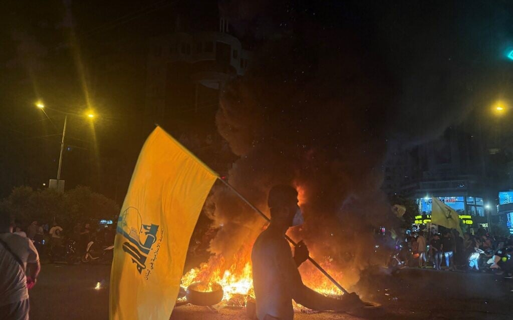 Supporters of Lebanon's Hezbollah terror group block the streets with burning tires as they rally in cars and motorbikes to protest the government's endorsement of a plan to disarm it, in Beirut's southern suburbs early on August 8, 2025. (Ibrahim Amro/AFP)