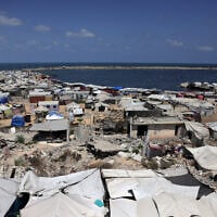 Tents used as temporary shelters by displaced Palestinians are set up around war-damaged structures along the beach in Gaza City on August 8, 2025. (Bashar Taleb/AFP)